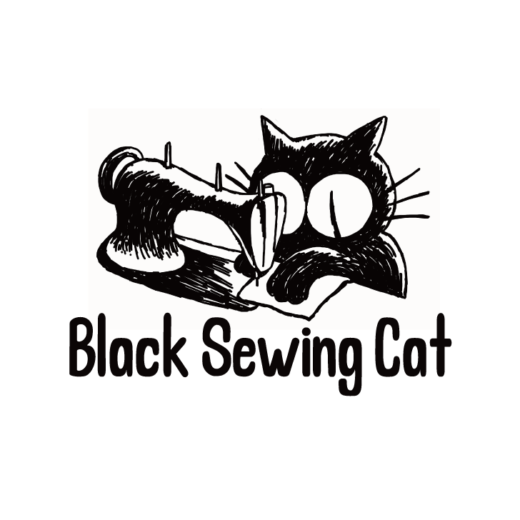 黒いミシンを踏む黒い猫